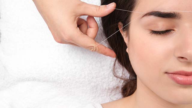 Woman having threading hair removal